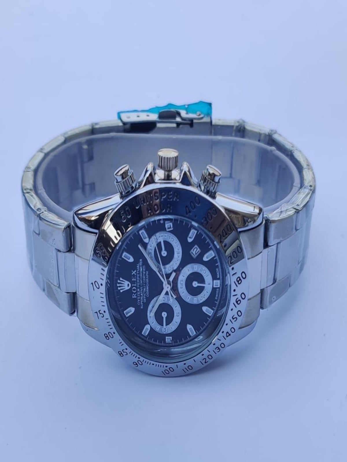 Silver watch with a blue face on a light blue background