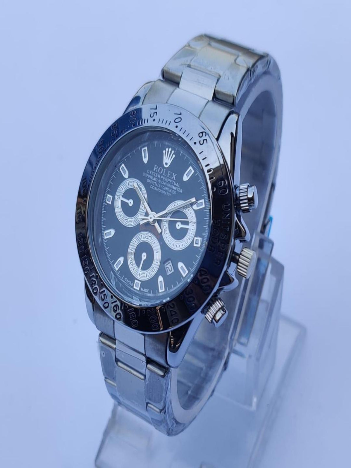 Silver watch with a black face on a light blue background