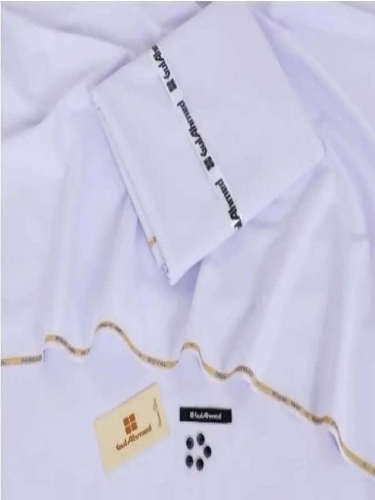 Men’s white unstitched wash and wear suit fabric laid out with tags and buttons.