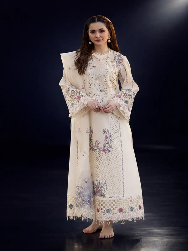 Woman in cream embroidered traditional outfit with dupatta on a dark background