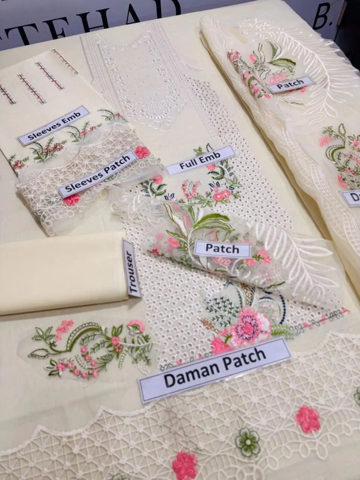 Off-white unstitched embroidered women's suit with floral patches and lace details